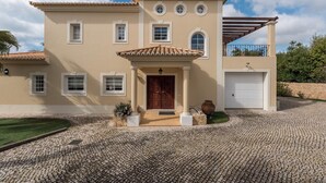 A two-story house with a tiled roof, a front porch, and a garage. - Villa Montemar, a 4 bedroom Self Check-in Villa walking distance to Carvoeiro (Carvoeiro)