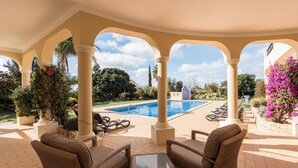 A covered patio with a pool, outdoor furniture, and a view of the pool and garden. - Villa Montemar, a 4 bedroom Self Check-in Villa walking distance to Carvoeiro (Carvoeiro)