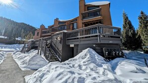 A modern building with a wooden facade, multiple balconies, and a staircase leading to a covered entrance. - Key Condo 2967d (Keystone)