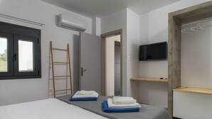 Une chambre moderne avec un lit, une échelle, un téléviseur et un placard.