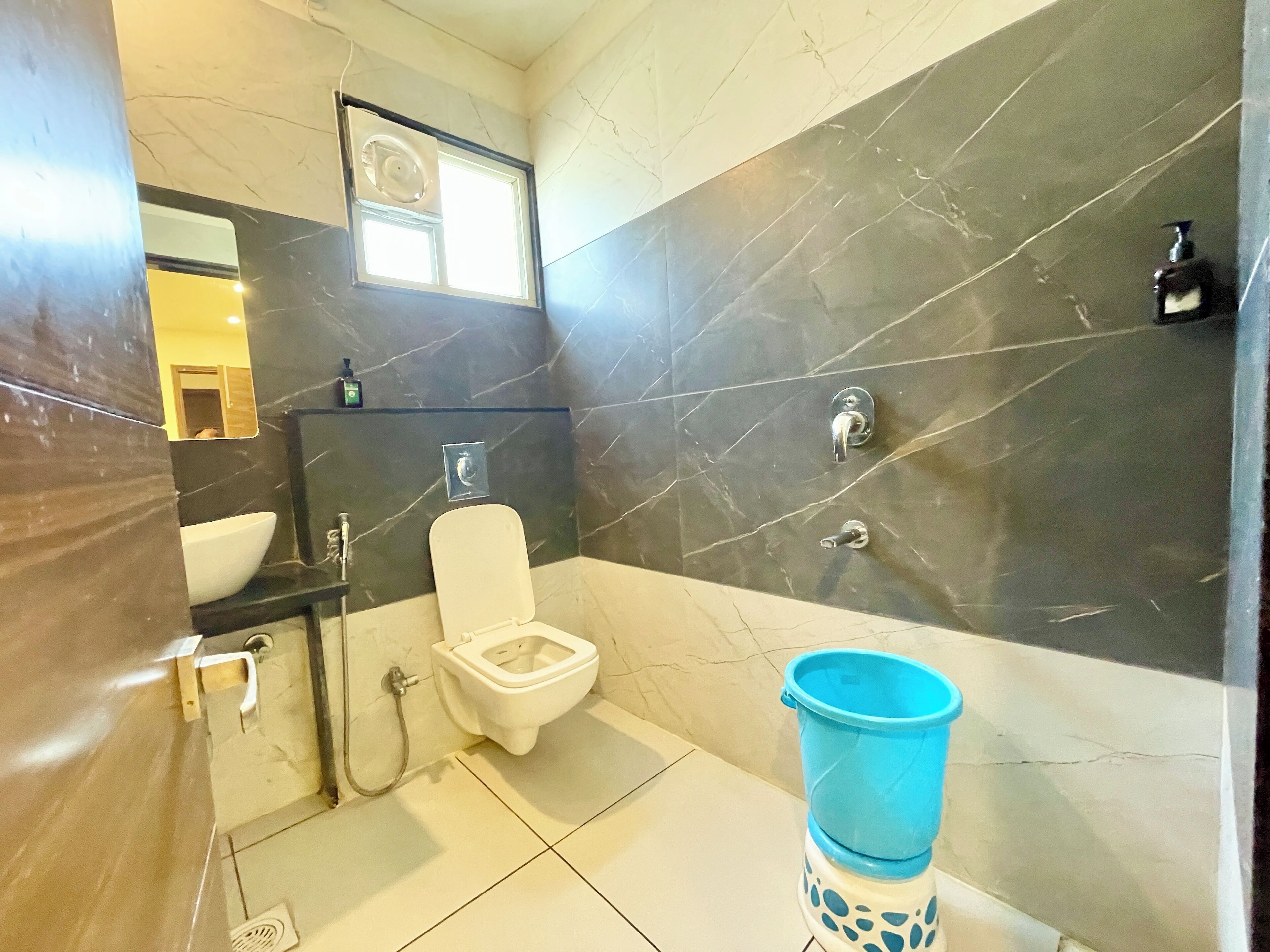 Une salle de bain avec des toilettes, un lavabo et une douche.