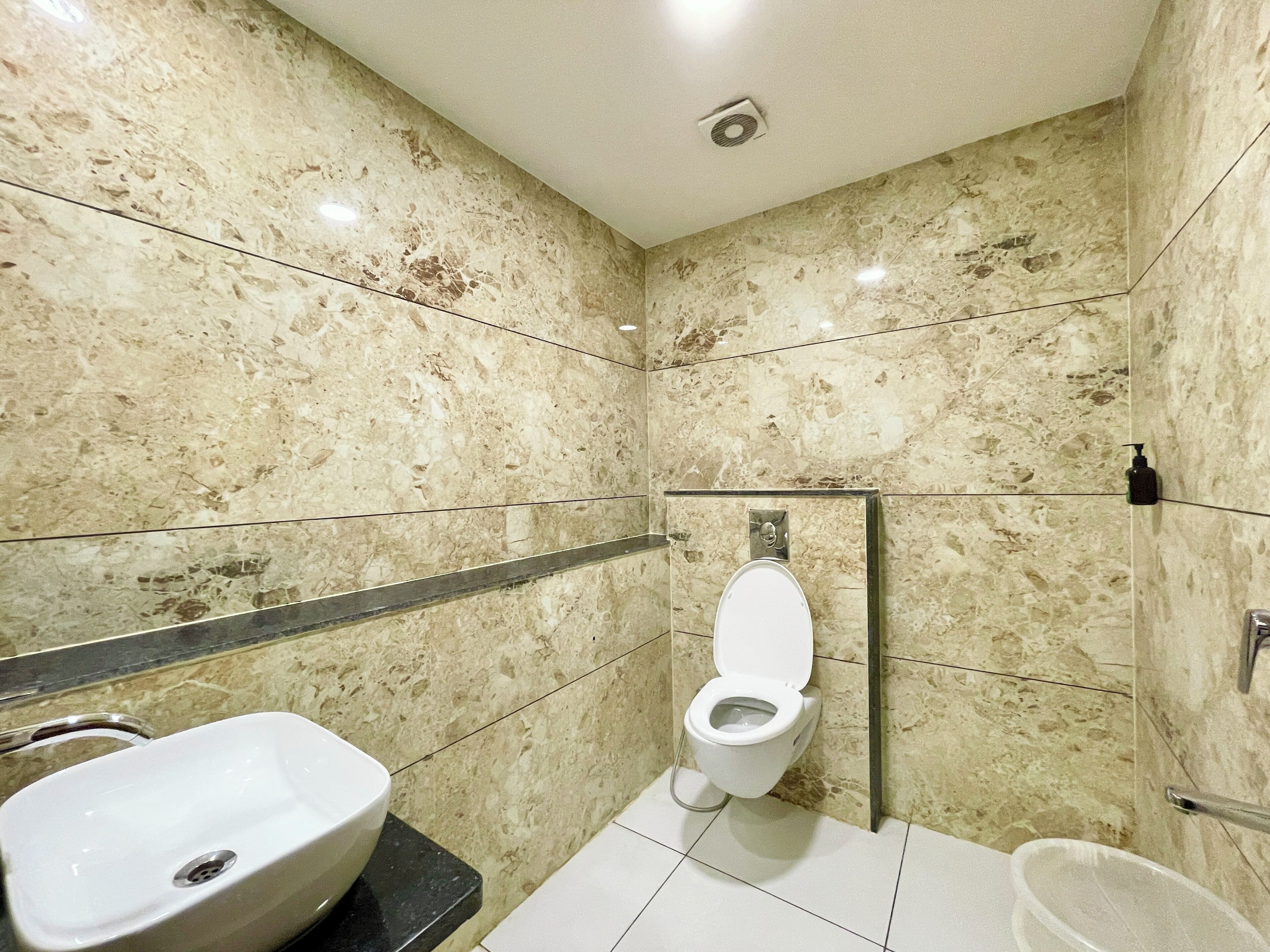 A bathroom with a toilet, sink, and shower area.