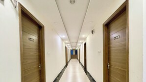 Un largo y estrecho pasillo de hotel con puertas de madera a ambos lados, numeradas 301 y 312.