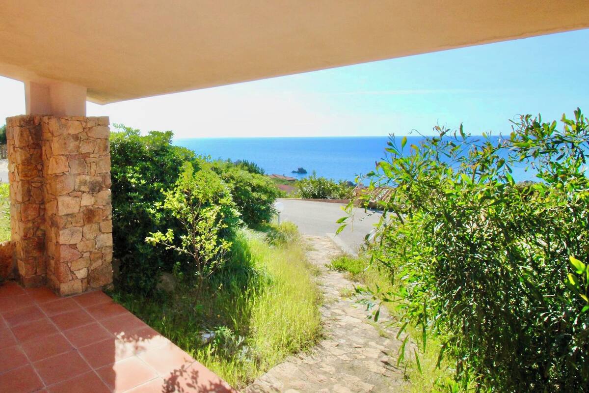 A stone pillar, a stone pathway, and a view of the ocean.