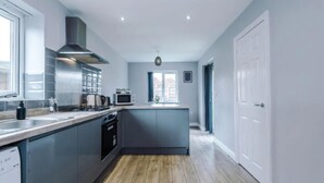 A modern kitchen with grey cabinets, a central island, a microwave, and a dishwasher. - House 3 Bed Sleeps 6 -pets Ok -patio -free Parking (Manchester)