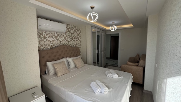 Une chambre d’hôtel équipée d’un lit, d’un canapé, d’un appareil de climatisation et d’un luminaire au plafond.