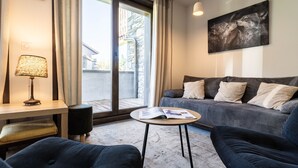Un salon moderne avec un canapé, une table basse, une lampe et un tableau au mur.