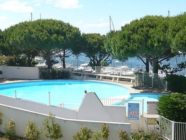 Piscina com vista para barcos e árvores.