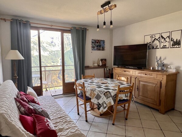 Un salon confortable avec un canapé, une table à manger et un téléviseur.