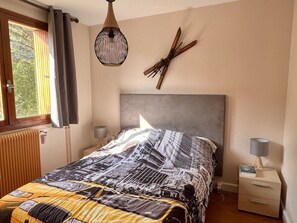 A bedroom with a bed, a nightstand, a lamp, a hanging light fixture, and a window with curtains. - 3-room apartment, 6 people - Pets allowed, near slopes (Orcières Merlette)
