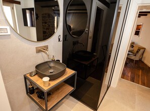 A modern bathroom with a large oval sink, a mirror, and a small table with a cup. - Luxury and Timeless Haven Apartment Rovinj (Rovinj)