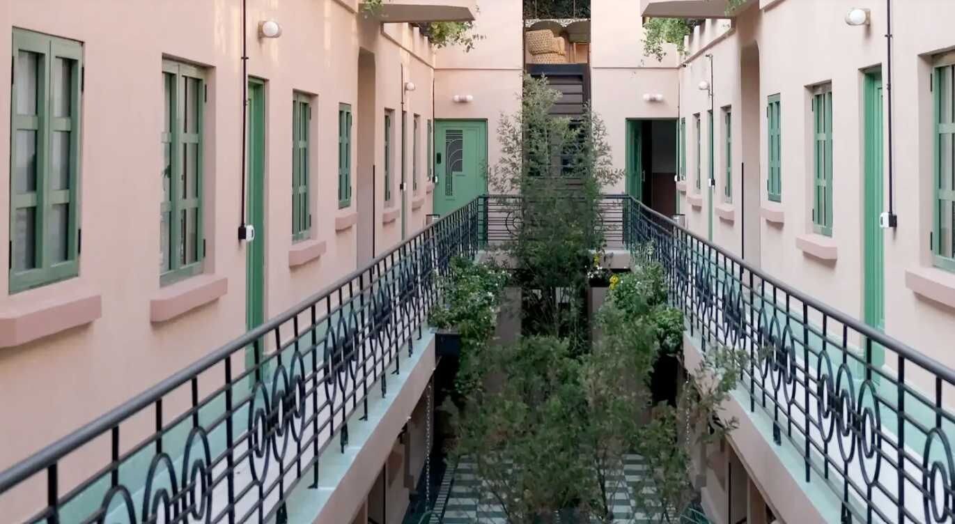 Un immeuble à plusieurs étages, doté de balcons et d’un escalier central.