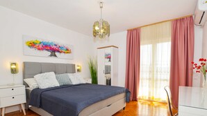 A modern bedroom with a bed, bedside tables, a nightstand, a mirror, and a window with curtains. - Cozy and Smart Rovinj Apartment With Balcony (Rovinj)