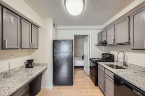 A compact kitchen with granite countertops, stainless steel appliances, and a walk-in pantry. - Overlook Club A2 l Spacious and cozy (Cumming)