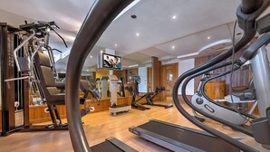 A gym with various exercise equipment including treadmills, stationary bikes, and weight machines. - Nivis Hotel  (Dimaro Folgarida)