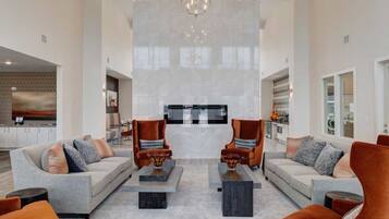A spacious living room with two sofas, a coffee table, and a chandelier.