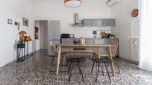 Una cocina moderna con armarios grises, una mesa de comedor de madera y una silla negra.