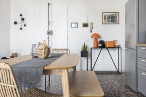 A modern kitchen with a dining table, chairs, a bench, a coffee machine, a plant, and a framed picture on the wall. - Casa Spritz, bright house near Piazza Cesare Beccaria (Firenze)