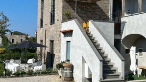 A stone building with a modern staircase and outdoor seating area. - Mille912 relais: Deluxe apartment  (Piano di Sorrento)