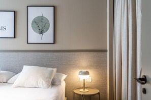 A hotel room with a bed, a bedside lamp, and two framed artworks on the wall. - STANDARD APARTMENT IN VALENCIA (València)