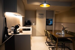 A modern kitchen with a central island, a dining area with a wooden table and chairs, and a hanging light fixture. - STANDARD APARTMENT IN VALENCIA (València)