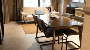 Un salon moderne avec une table à manger en verre, un canapé et une table basse.
