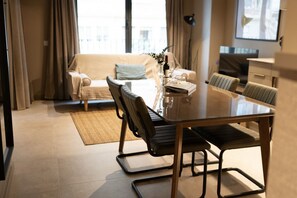 A modern living room with a glass dining table, a sofa, and a coffee table. - STANDARD APARTMENT IN VALENCIA (València)