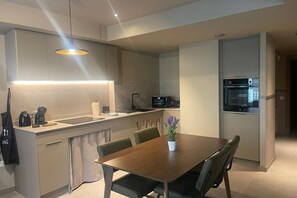 A modern kitchen with a central island, built-in appliances, and a dining area with a table and chairs. - STANDARD APARTMENT IN VALENCIA (València)