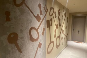 Ein Korridor mit einer strukturierten Wand und einer Tür am Ende.