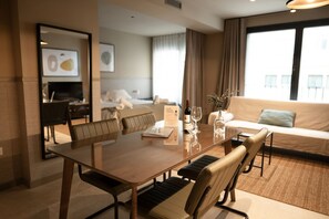 A modern hotel room with a dining area, a sofa, and a large window. - STANDARD APARTMENT IN VALENCIA (València)