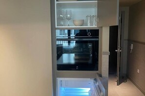 A compact kitchen with a built-in oven and a refrigerator. - STANDARD APARTMENT IN VALENCIA (València)