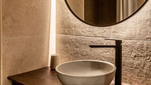 A bathroom with a large round mirror, a modern sink, and a textured wall. - STANDARD APARTMENT IN VALENCIA (València)