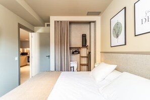 A hotel room with a bed, a desk, a chair, a lamp, and a framed artwork on the wall. - APARTMENT WITH TERRACE IN VALENCIA (València)