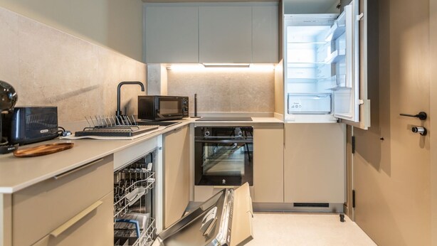 A compact kitchen with a built-in oven, a microwave, and a dishwasher.