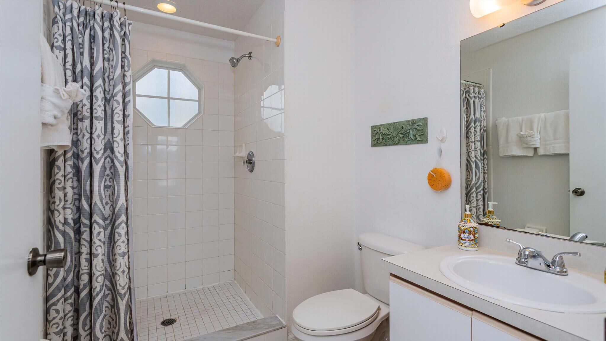 Un baño con ducha, inodoro y lavamanos.