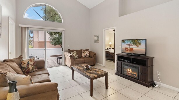 A living room with a fireplace, a television, and a sofa. - Cozy Home Near Disney!!! (Kissimmee)