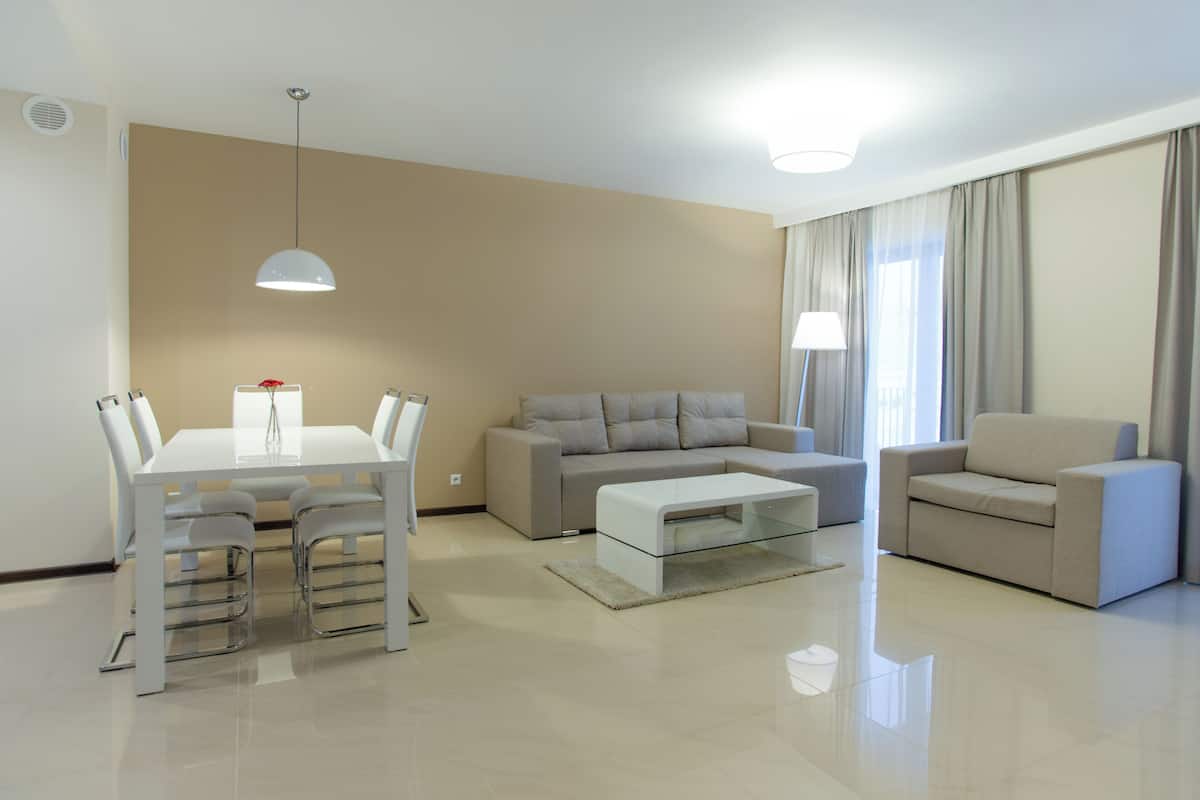 Una sala de estar moderna con una mesa de comedor, dos sofás y una mesa de centro.