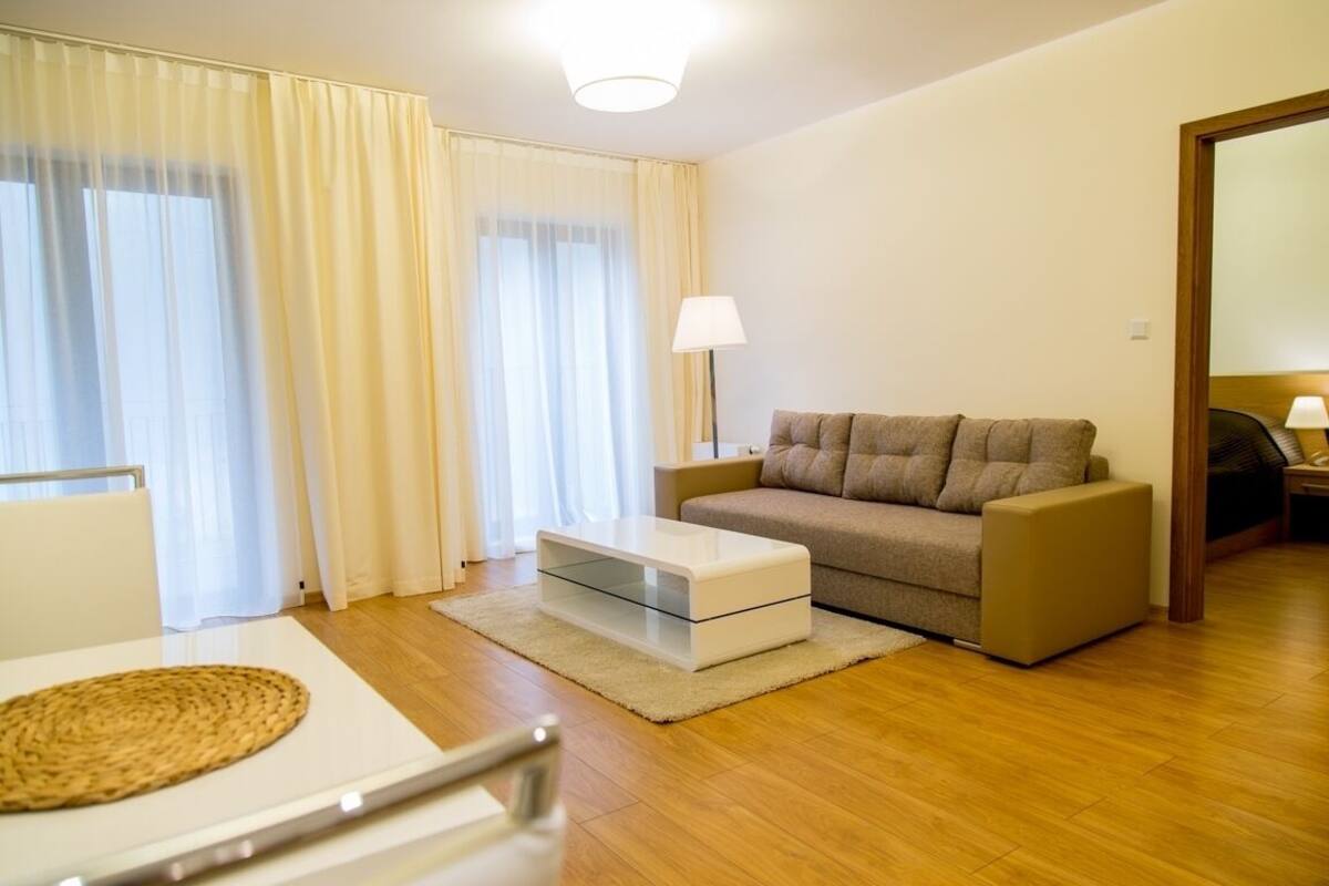 Una sala de estar moderna con un sofá, una mesa de centro y una lámpara.