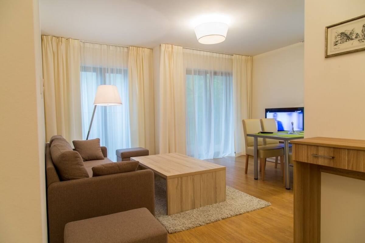 Una sala de estar moderna con un sofá, una mesa de centro y un escritorio con una computadora.