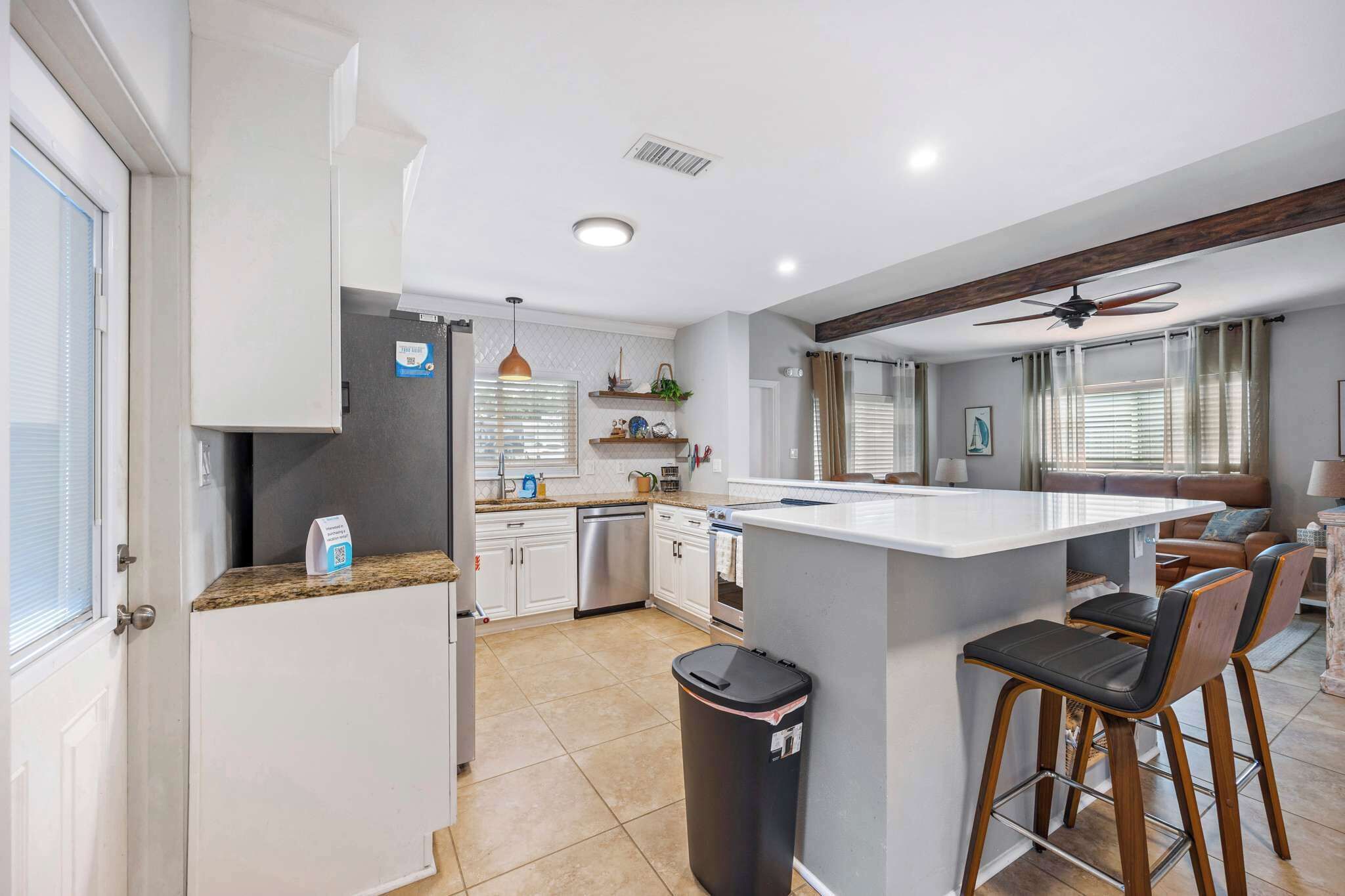Open kitchen with a breakfast bar and modern appliances overlooking the living area.