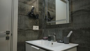 A bathroom with a white sink, a mirror, and a towel rack. - Designer Apartment Steps Away from Main Attractions (Yerevan)