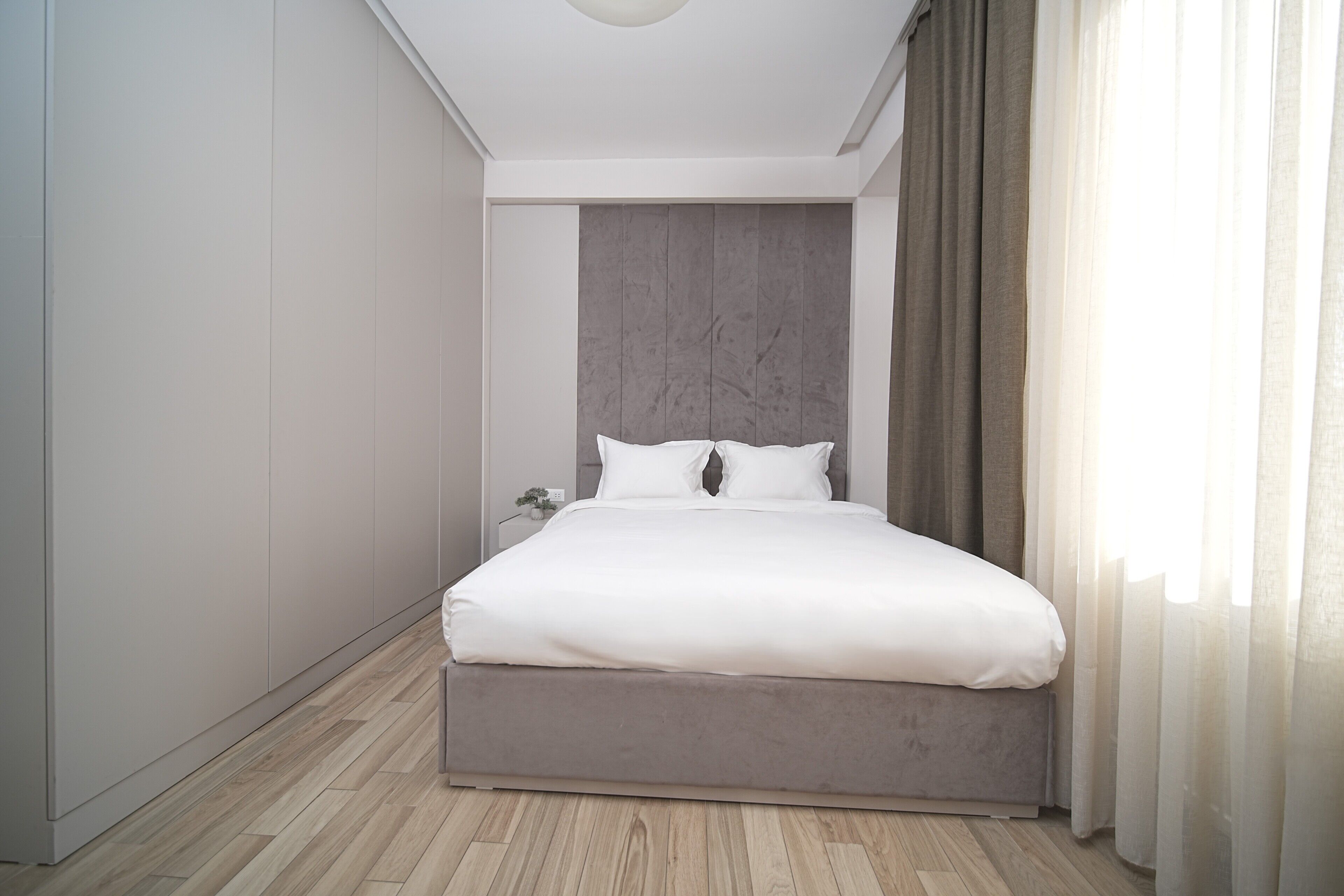 Une chambre à coucher moderne avec un grand lit, une tête de lit et une table de chevet.