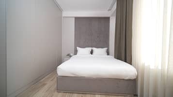 Une chambre à coucher moderne avec un grand lit, une tête de lit et une table de chevet.