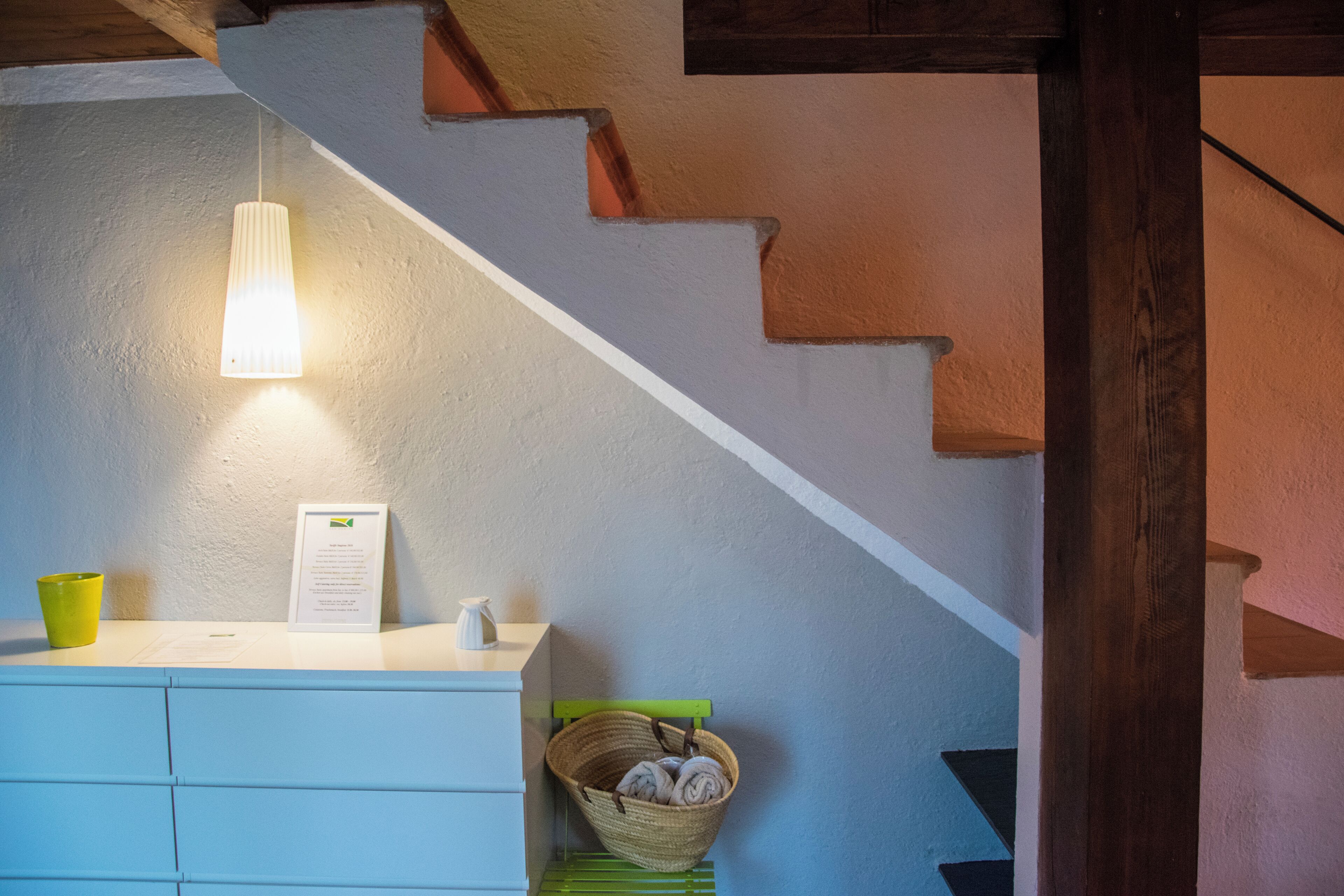 Un escalier avec un mur blanc et une main courante en bois.