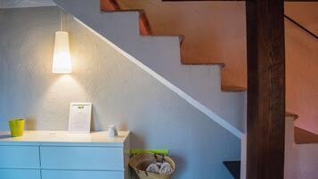 Un escalier avec un mur blanc et une main courante en bois.