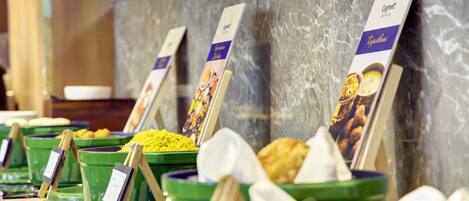A buffet with labeled food containers and a marble countertop.