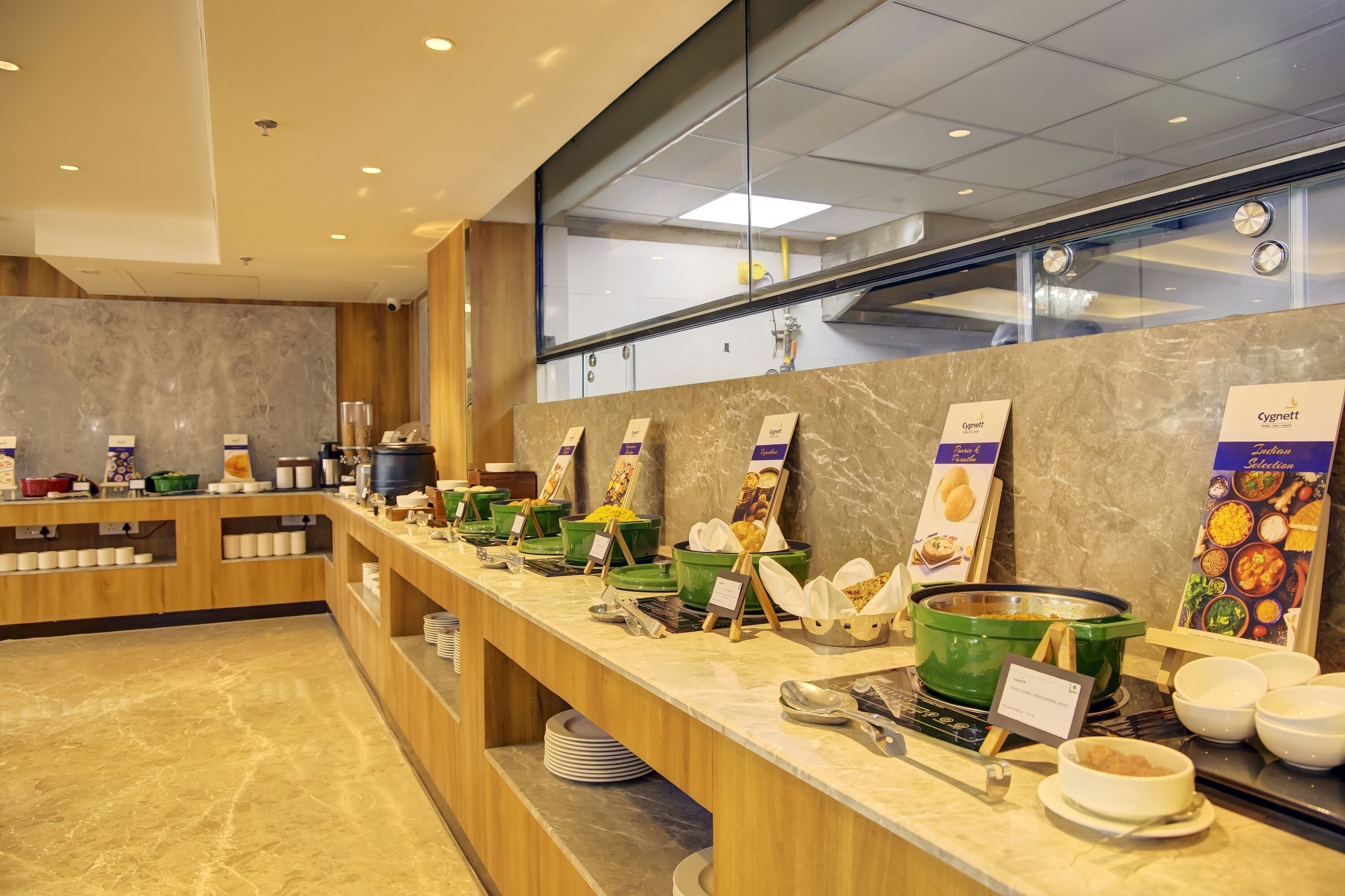 En buffet med flere madstationer, herunder en station med grøn suppe og et udvalg af friskbagte kager.