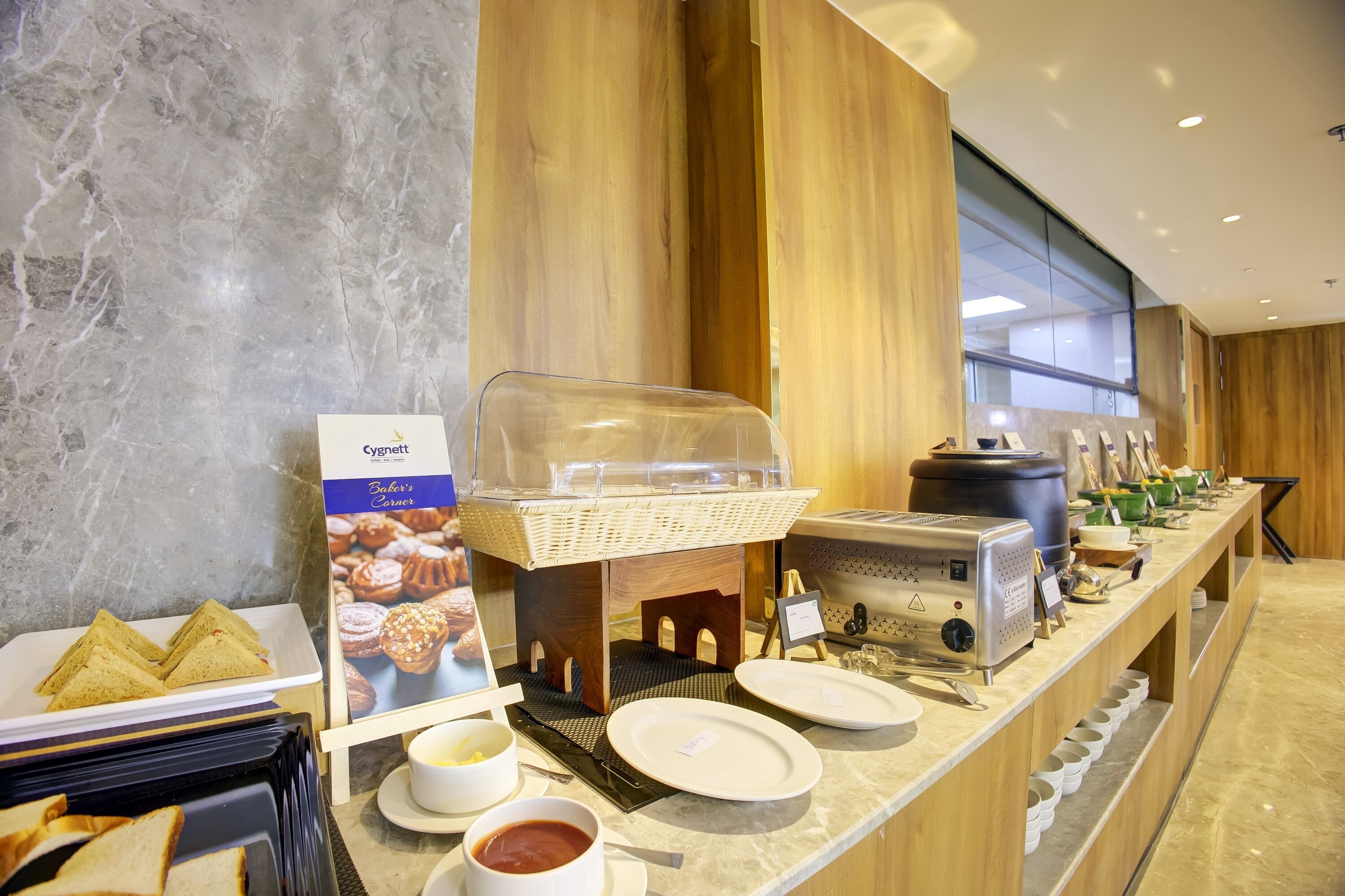 A breakfast buffet with sandwiches, pastries, and a coffee station.