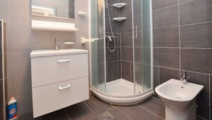 A modern bathroom with a glass-enclosed shower, a white vanity, and a bidet. - Quiet and Compact Apartment With Balcony (Rovinj)