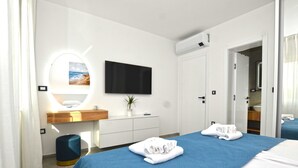 Ein Hotelzimmer mit einem Bett, einem Fernseher, einem Spiegel, einem Waschbecken und einem Kleiderschrank.